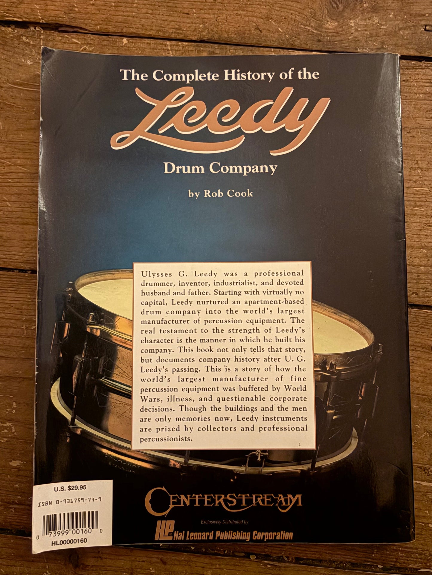 Book titled 'The Complete History of the Leedy Drum Company' on a wooden surface